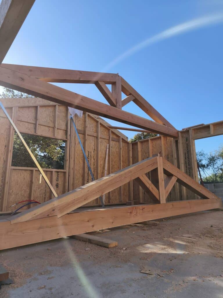 Fermes de charpente en bois massif sur un chantier de maison individuelle en cours de construction.